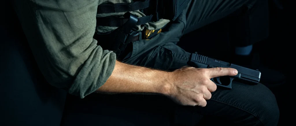 Dumars rests a Gen 5 Glock 17 on his thigh inside the MRAP in The Rip, finger off the trigger
