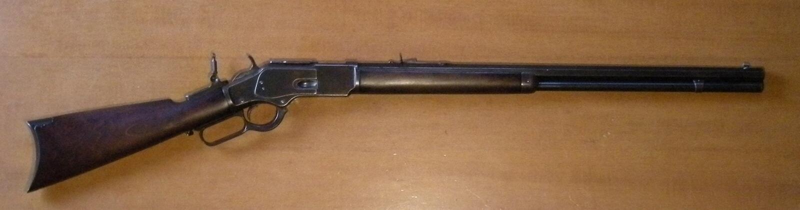 Antique Winchester Model 1873 lever-action rifle with a walnut stock