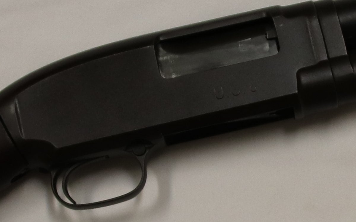 Right side of a Winchester Model 12 receiver showing the ejection port, U.S. stamp and crossbolt safety at the trigger guard