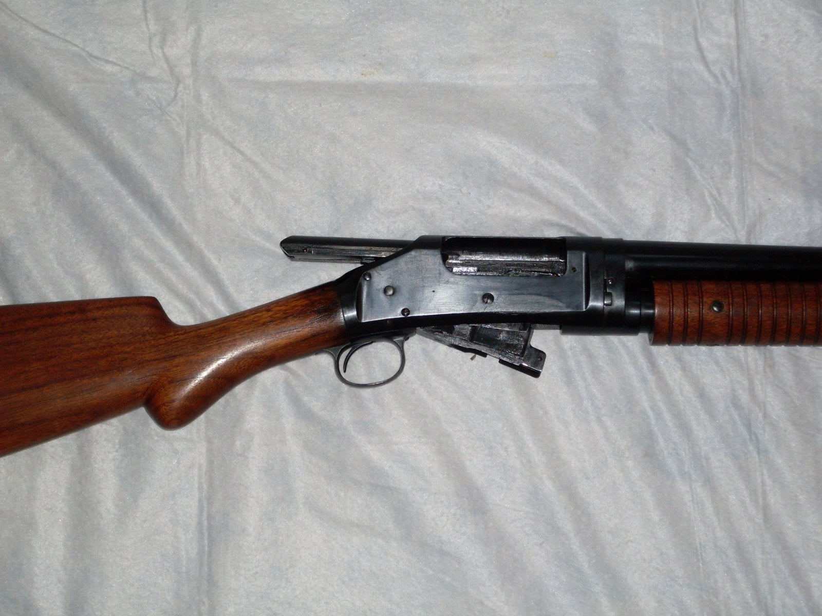 Winchester Model 1897 with the action open, showing the bolt pulled back and the shell carrier dropped