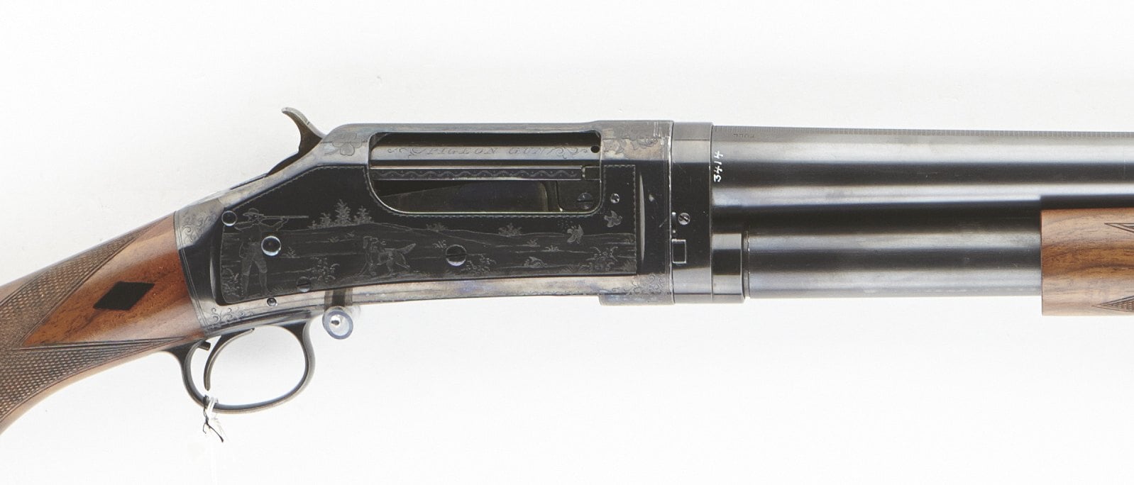 Engraved receiver of a Winchester Model 1897 Pigeon Grade shotgun with a hunting scene