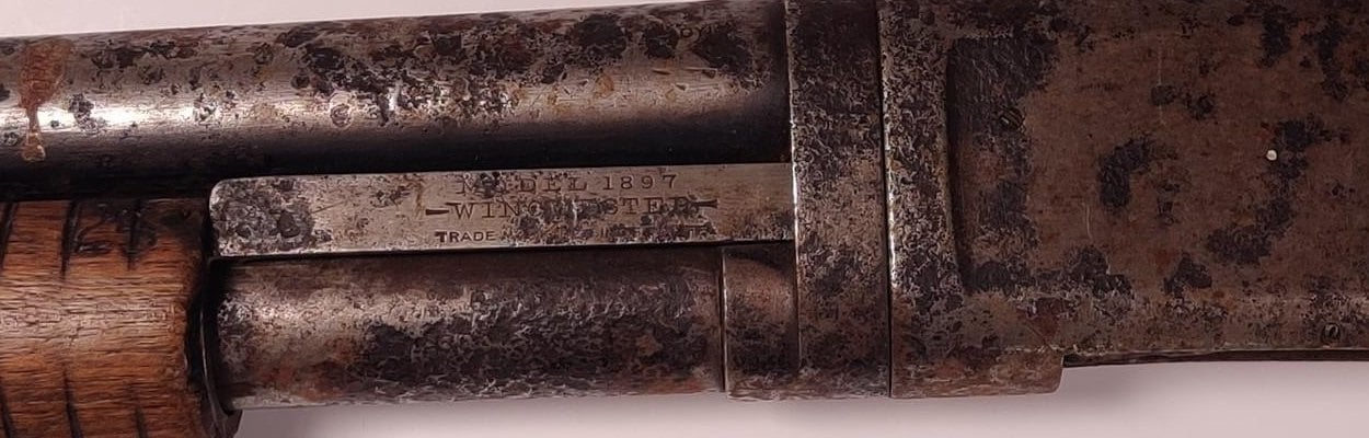 Model 1897 Winchester Trade Mark roll mark stamped on the action slide of a worn Model 1897 shotgun