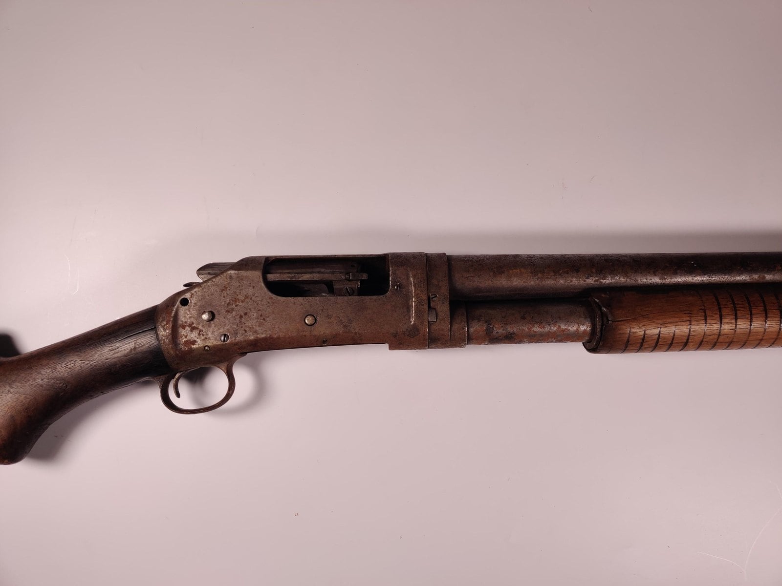 Heavily rusted Winchester Model 1897 receiver with exposed hammer and ejection port showing deep pitting