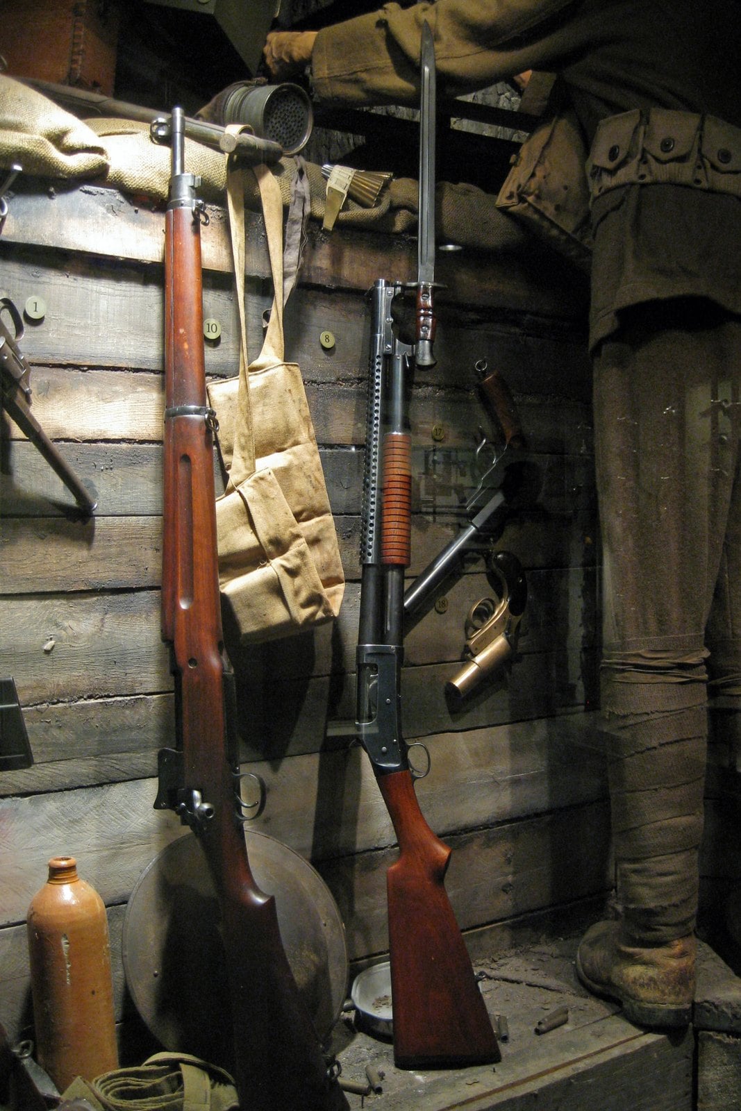 Winchester Model 1897 trench gun with perforated heat shield and M1917 bayonet fixed in a WWI museum display