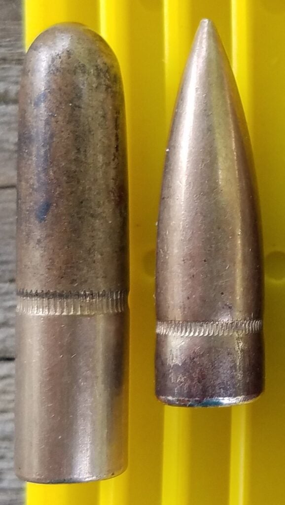 A 220 grain round nose rifle bullet beside a 150 grain pointed spitzer bullet