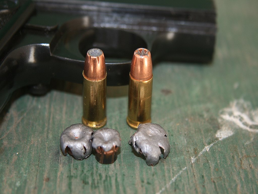 Two 25 ACP hollow point rounds and three expanded bullets on a green board