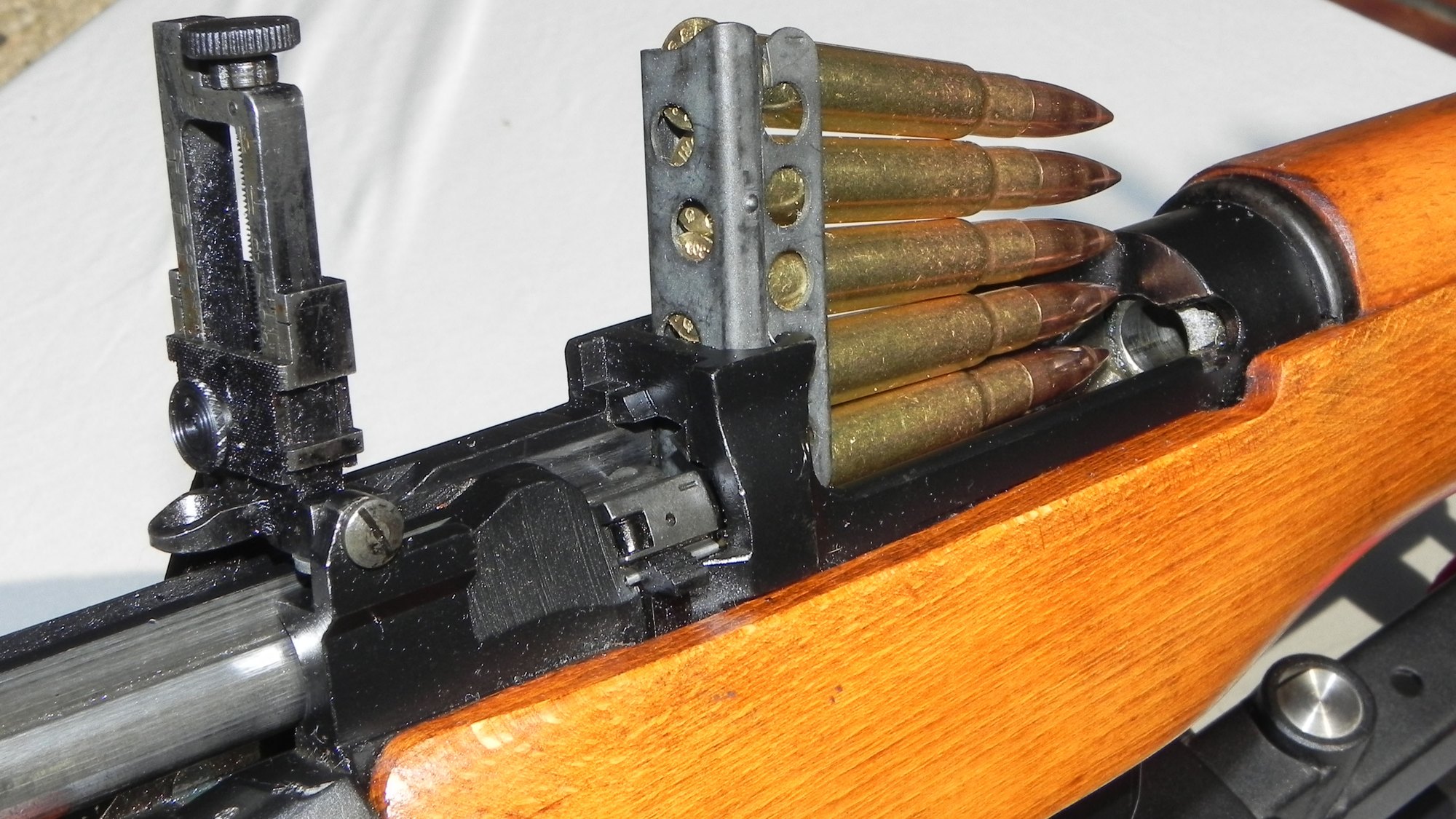 Five-round 303 British charger clip standing in the charger guide of a Lee-Enfield No. 4 rifle