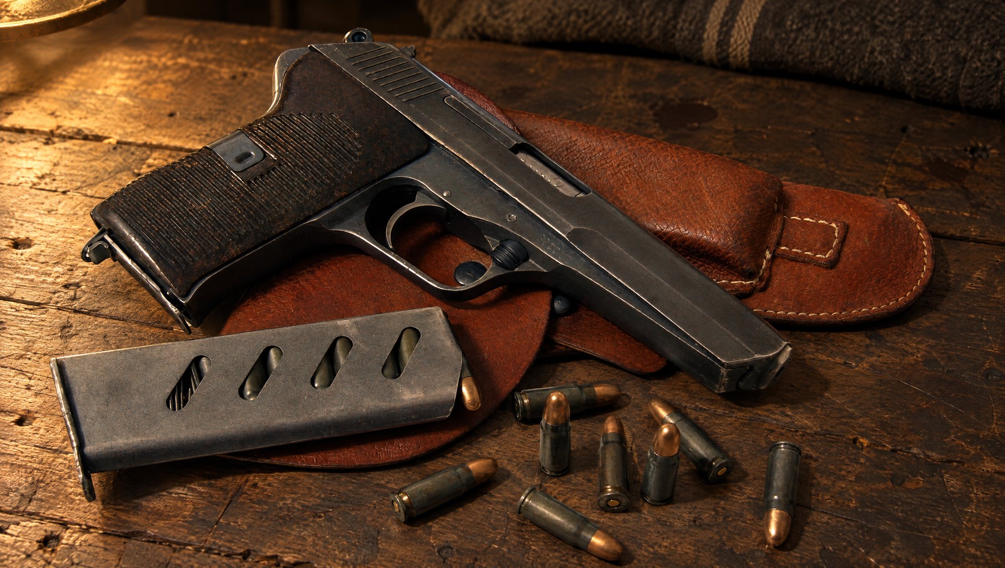 Loose 7.62x25 ammo and a magazine beside a CZ 52 Tokarev-caliber pistol on its leather holster