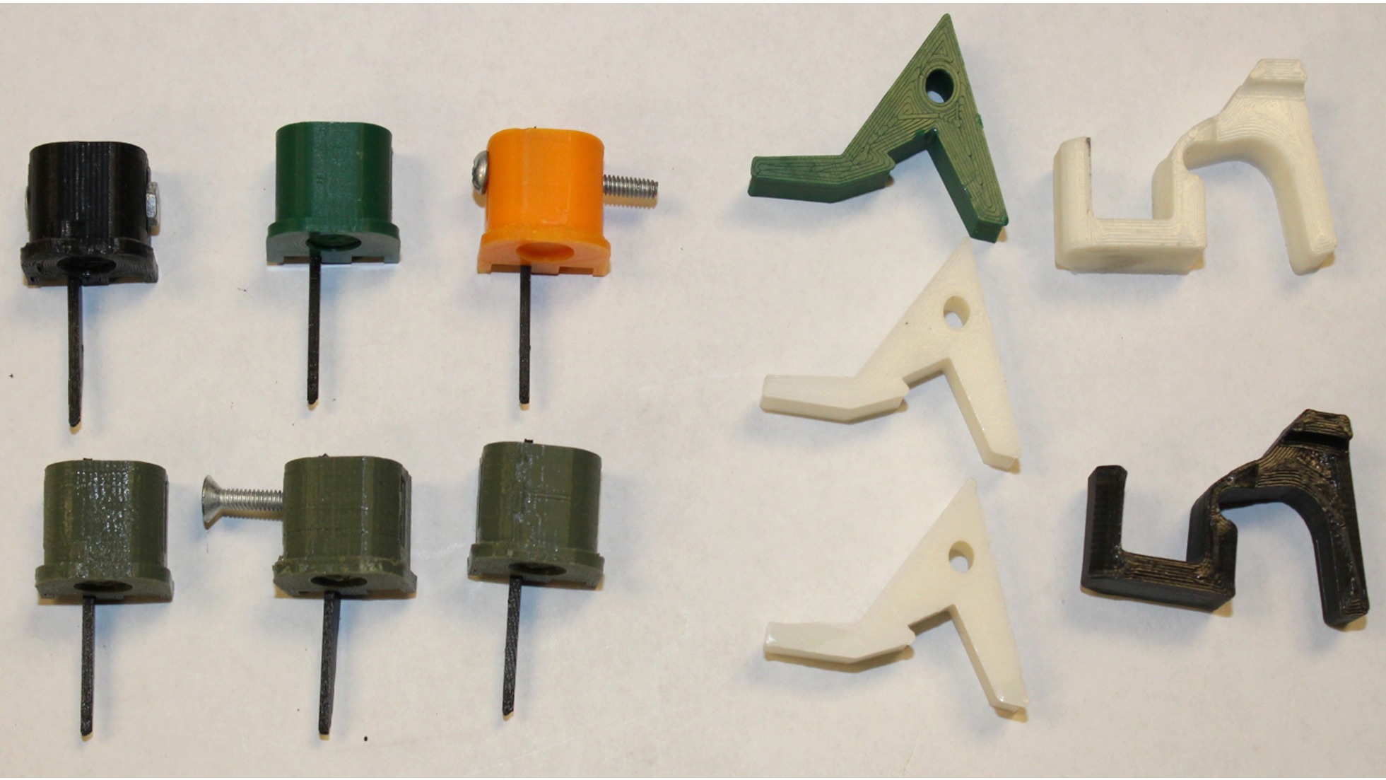 Seized 3D-printed Glock switches and AR-15 swift link conversion devices laid out on a table