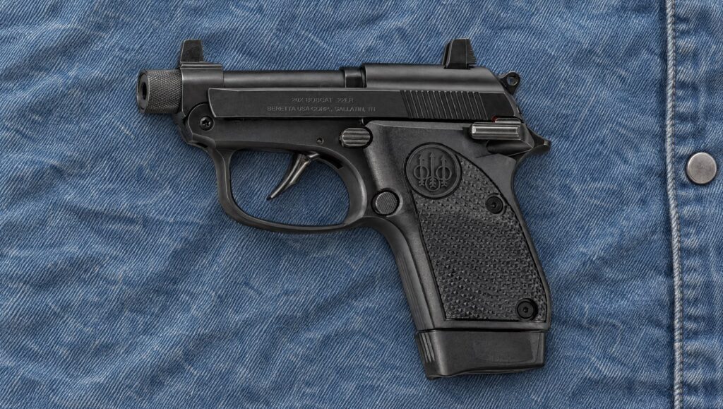 Beretta 20X Bobcat .22 LR pocket pistol with a threaded barrel lying flat on a blue denim shirt, left side showing the 20X BOBCAT slide marking and extended magazine
