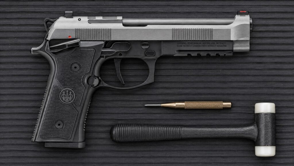 Beretta 92XI SAO with gray slide, black frame and frame-mounted thumb safety lying flat on a black rubber bench mat
