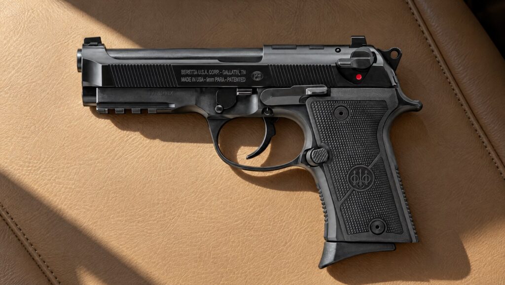 Beretta 92X RDO Compact 9mm pistol lying flat on a tan leather seat in low morning sun, left side showing the Beretta U.S.A. Corp. Gallatin, TN slide marking, rail and finger-rest magazine