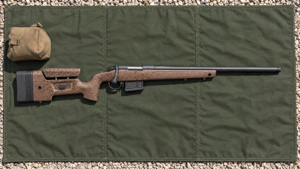 Bergara B-14 HMR with brown speckled mini-chassis stock, adjustable cheekpiece and AICS magazine lying flat on a green shooting mat