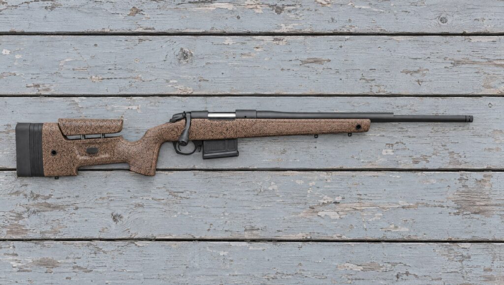 Bergara B-14 HMR with a brown speckled mini-chassis stock lying flat on a weathered shooting bench