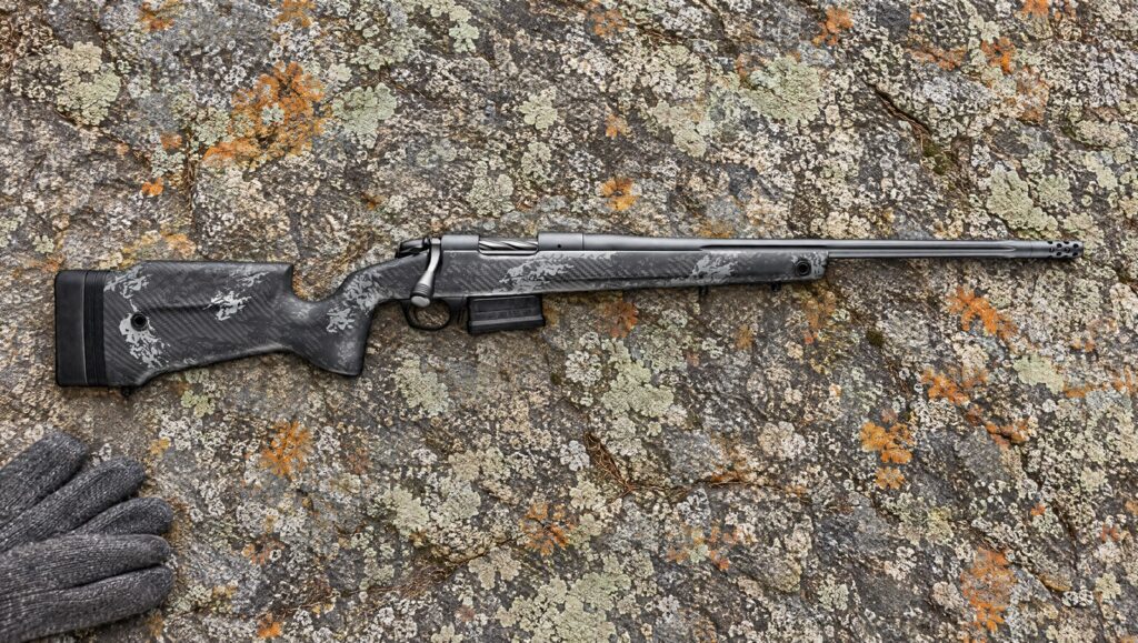 Bergara B-14 Squared Crest with carbon fiber stock, fluted steel barrel and Omni muzzle brake lying flat on lichen-covered granite
