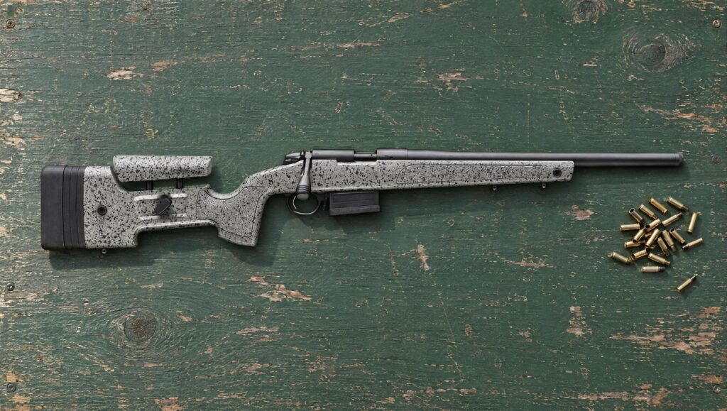 Bergara B-14R Steel .22 LR trainer with gray speckled HMR stock and steel barrel lying flat on a green range bench