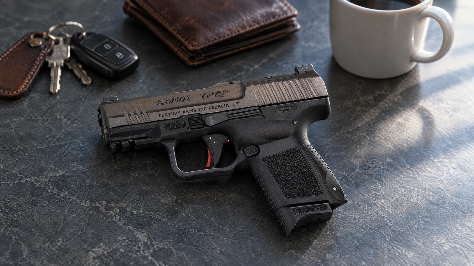 Canik TP9 Elite SC in Tungsten lying on a slate countertop beside car keys, a wallet and a coffee mug