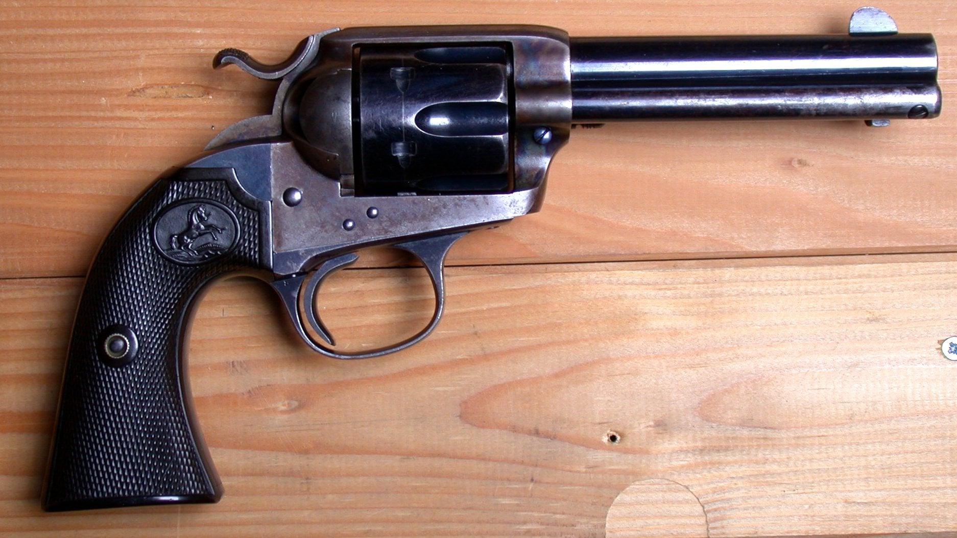 Blued Colt Bisley revolver in 38-40 on a pine board, right side