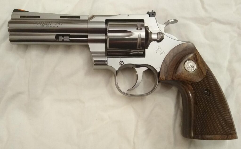 Left side of a 2020 production Colt Python in polished stainless steel with a short vent rib barrel and laminated walnut grips, the barrel marked Python 357