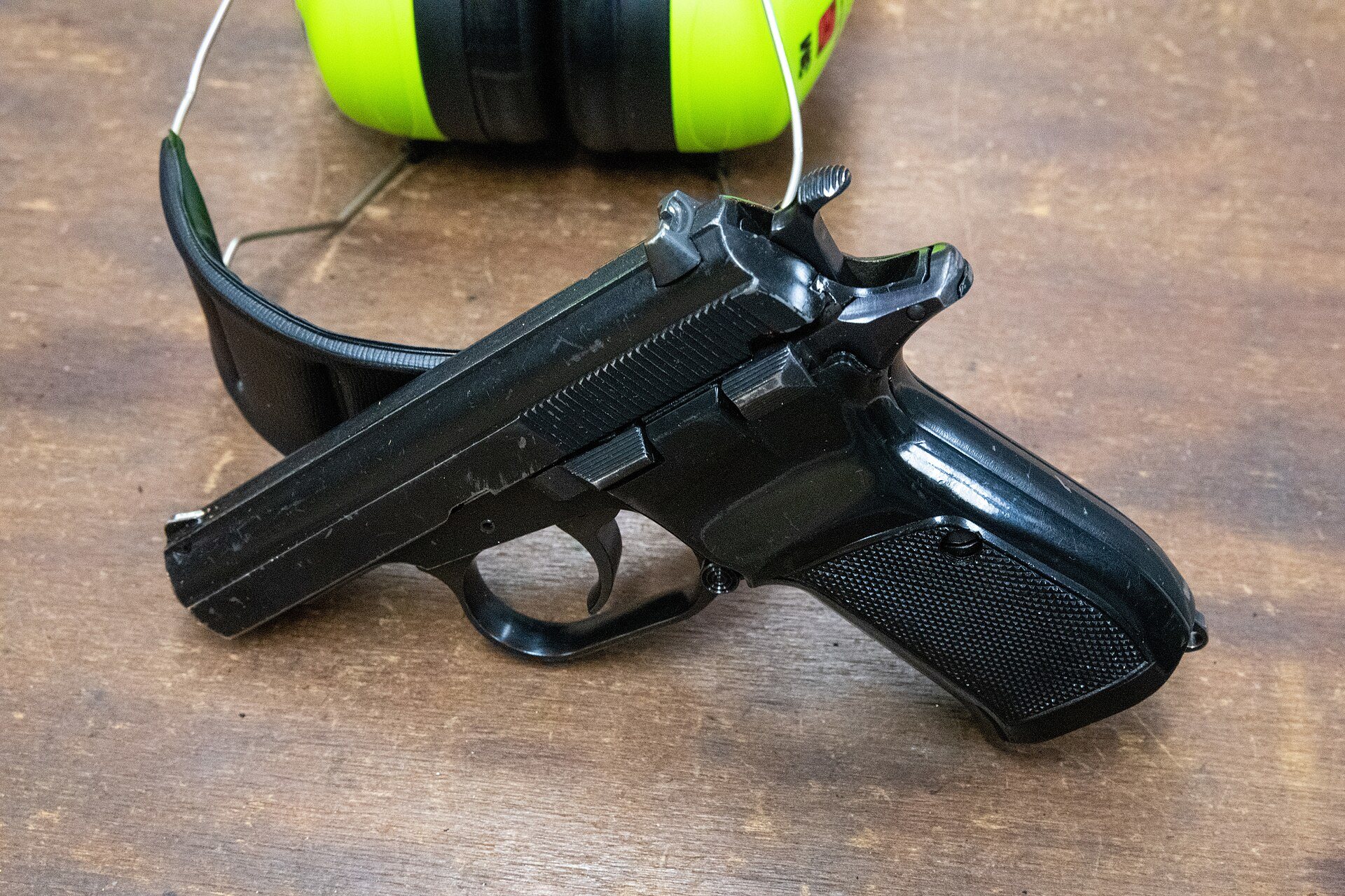 CZ 82 pistol resting on safety glasses on a wooden range bench