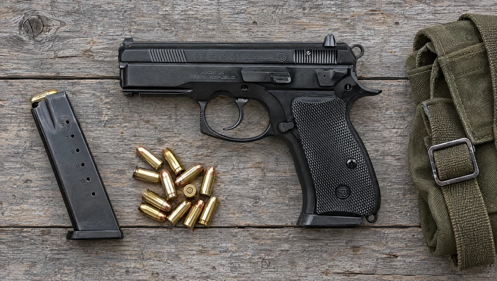 CZ 75 P-01 9mm lying flat on a weathered barn-wood table beside a magazine and loose 9mm cartridges