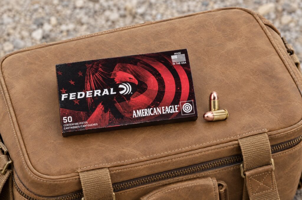 Federal American Eagle 380 Auto 95 grain FMJ box and cartridge resting on a tan leather range bag