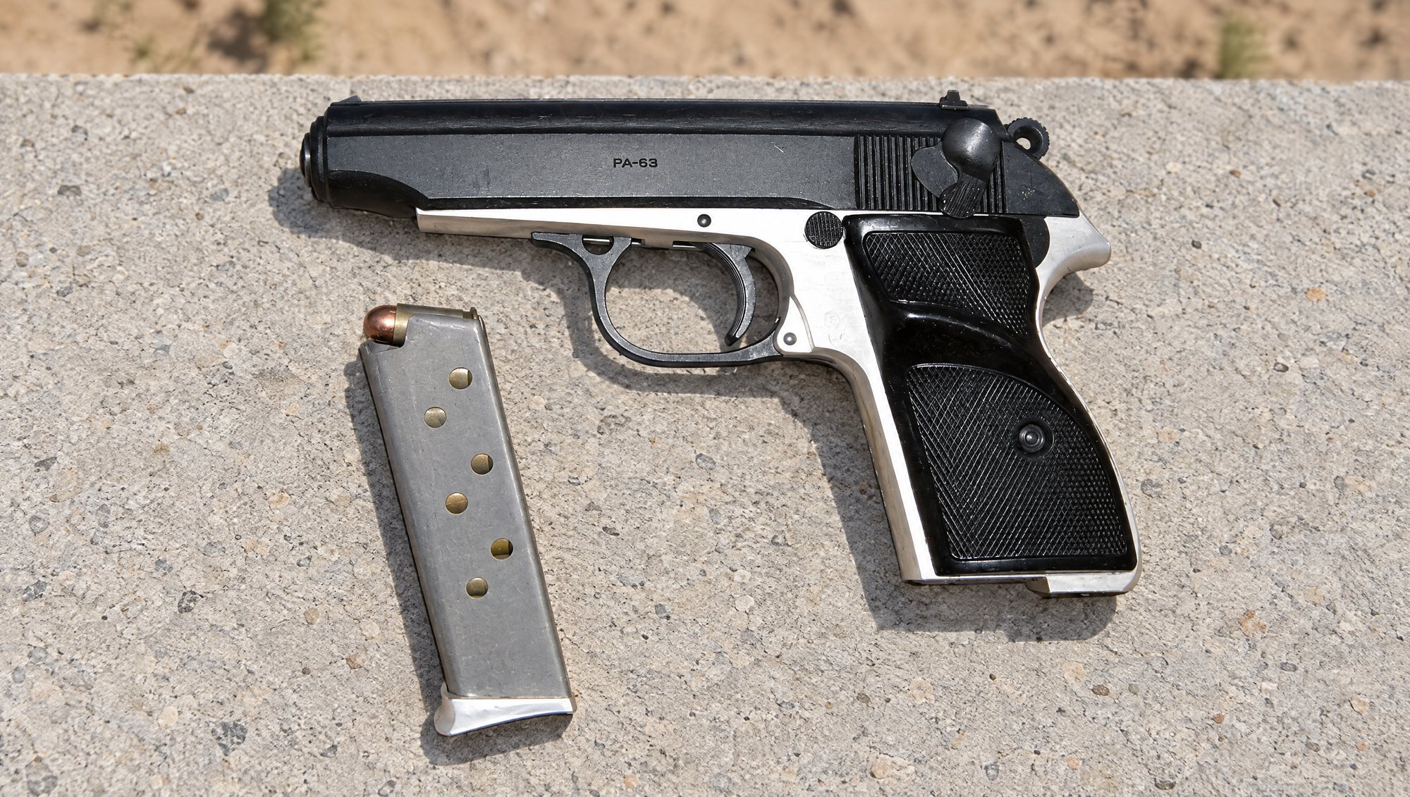 FEG PA-63 pistol and its loaded magazine on a concrete shooting bench