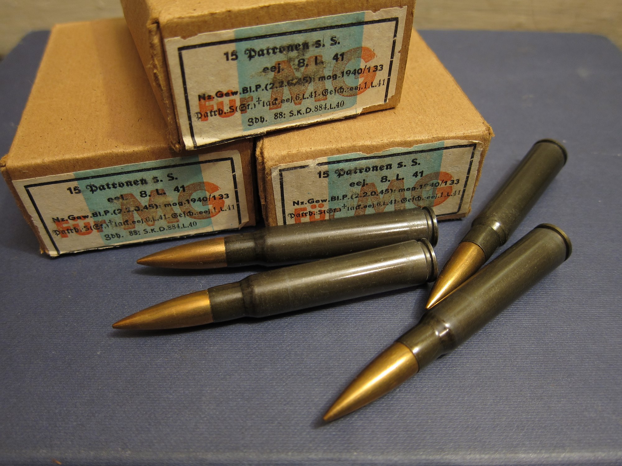 Three German WWII 15-round boxes of 7.92x57 s.S. ammunition with four steel-case cartridges