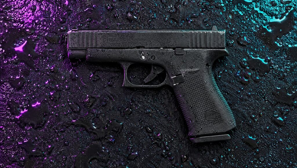 Black Glock 48 pistol lying on a rain-wet rooftop at night with neon reflections