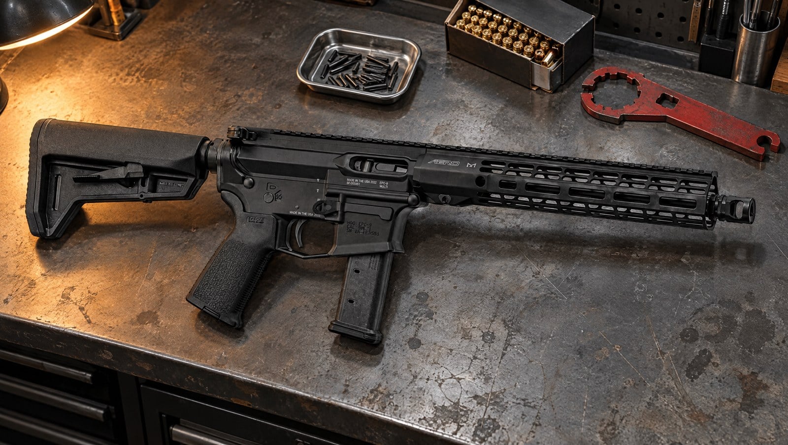 Aero Precision EPC-9 9mm carbine build lying on a steel workbench with an armorer wrench, roll pins and 9mm ammunition