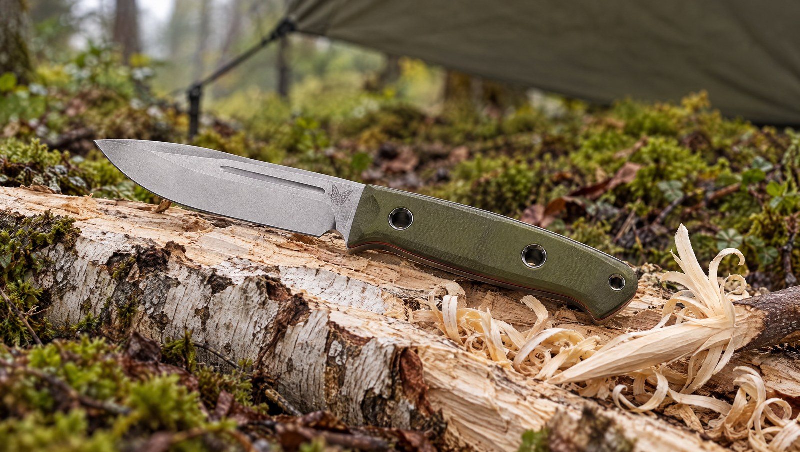 Benchmade 163-1 Bushcrafter knife on a split birch log with wood shavings at a forest camp
