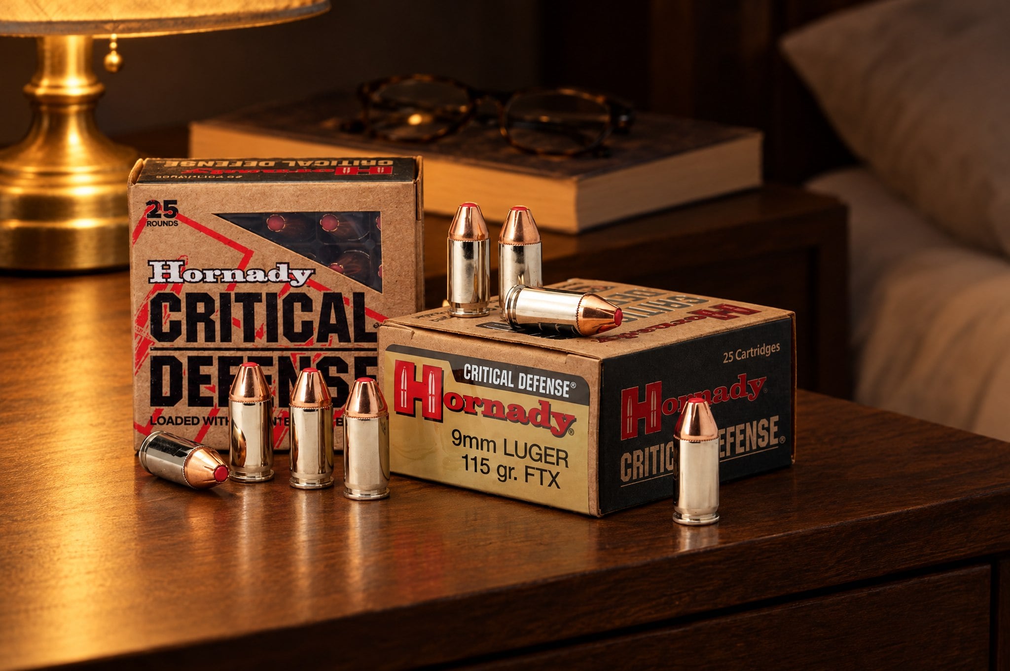 Hornady Critical Defense 9mm Luger 115 gr FTX ammo boxes and red-tipped cartridges on a walnut nightstand at night