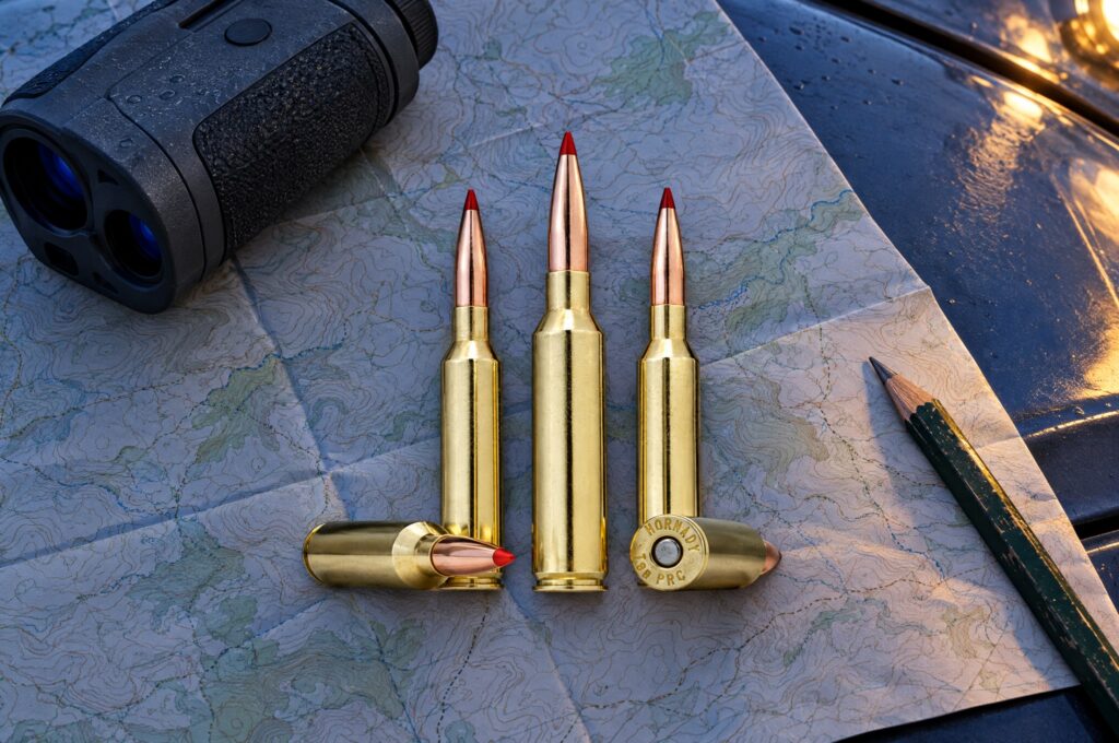 Hornady Precision Hunter 7mm PRC 175 gr ELD-X cartridges on a topographic map beside a laser rangefinder