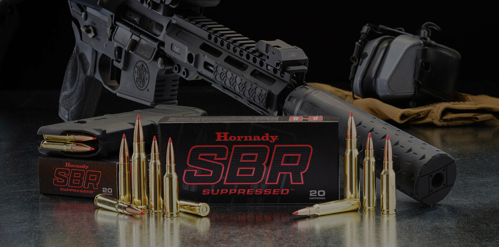Hornady SBR Suppressed ammunition boxes and cartridges beside a suppressed AR pistol
