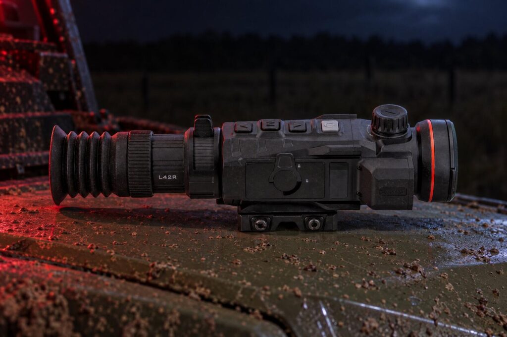 Nocpix Rico 2 L42R thermal scope with rangefinder on the muddy hood of a side-by-side at night under a red headlamp