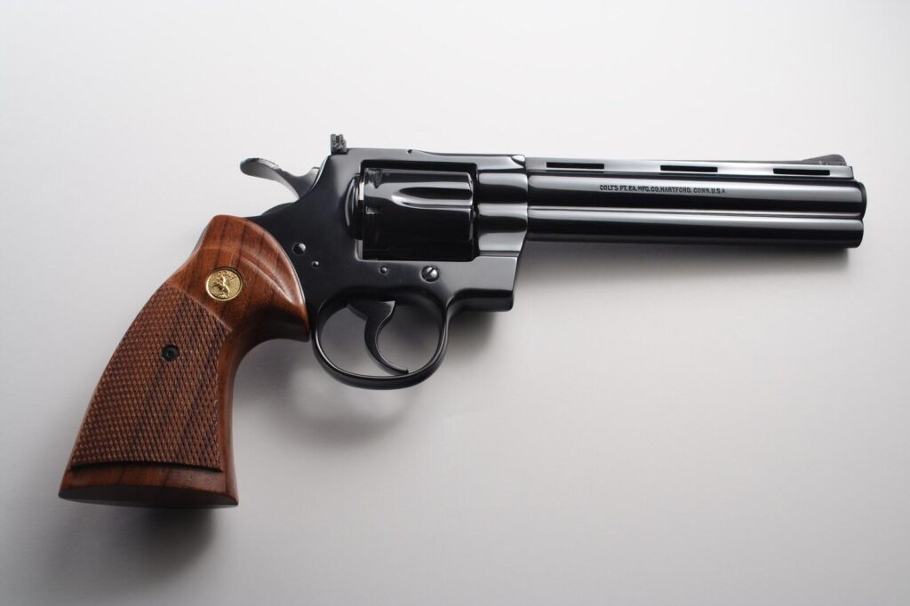 Right side of an original Colt Python with a six inch vent rib barrel, polished blue finish and checkered walnut target grips, the barrel marked with the Colt Hartford address