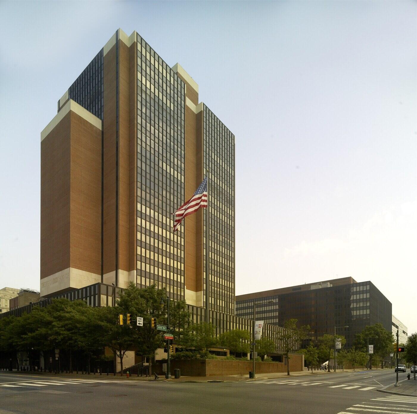 James A. Byrne U.S. Courthouse in Philadelphia, a brick and glass tower with a US flag out front
