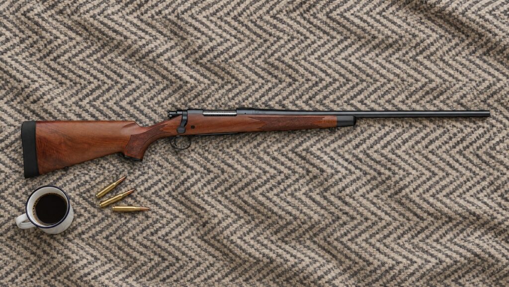 Remington 700 CDL with satin walnut stock, black forend tip, hinged floorplate and blued barrel lying flat on a herringbone wool blanket