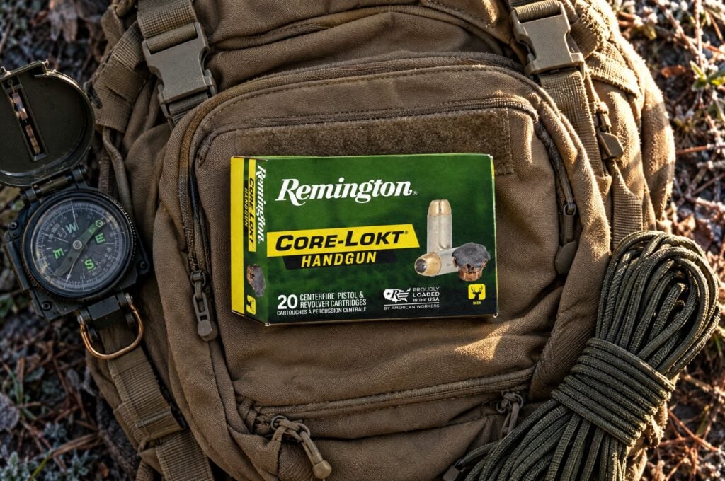 Remington Core-Lokt Handgun 10mm Auto 200 grain hollow point box on a tan hunting pack with a compass and paracord