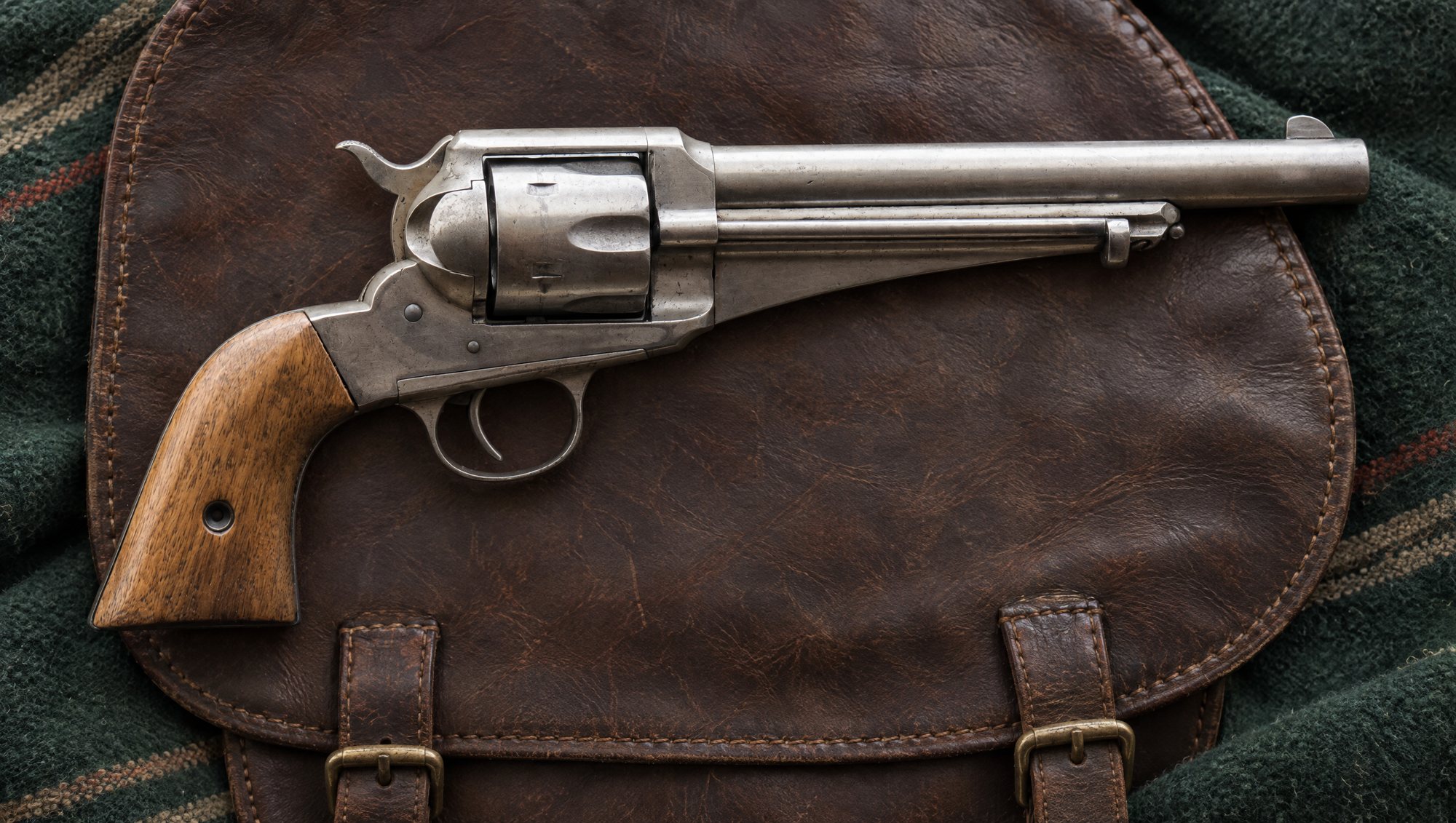 Nickel Remington Model 1875 revolver lying on a brown leather saddlebag