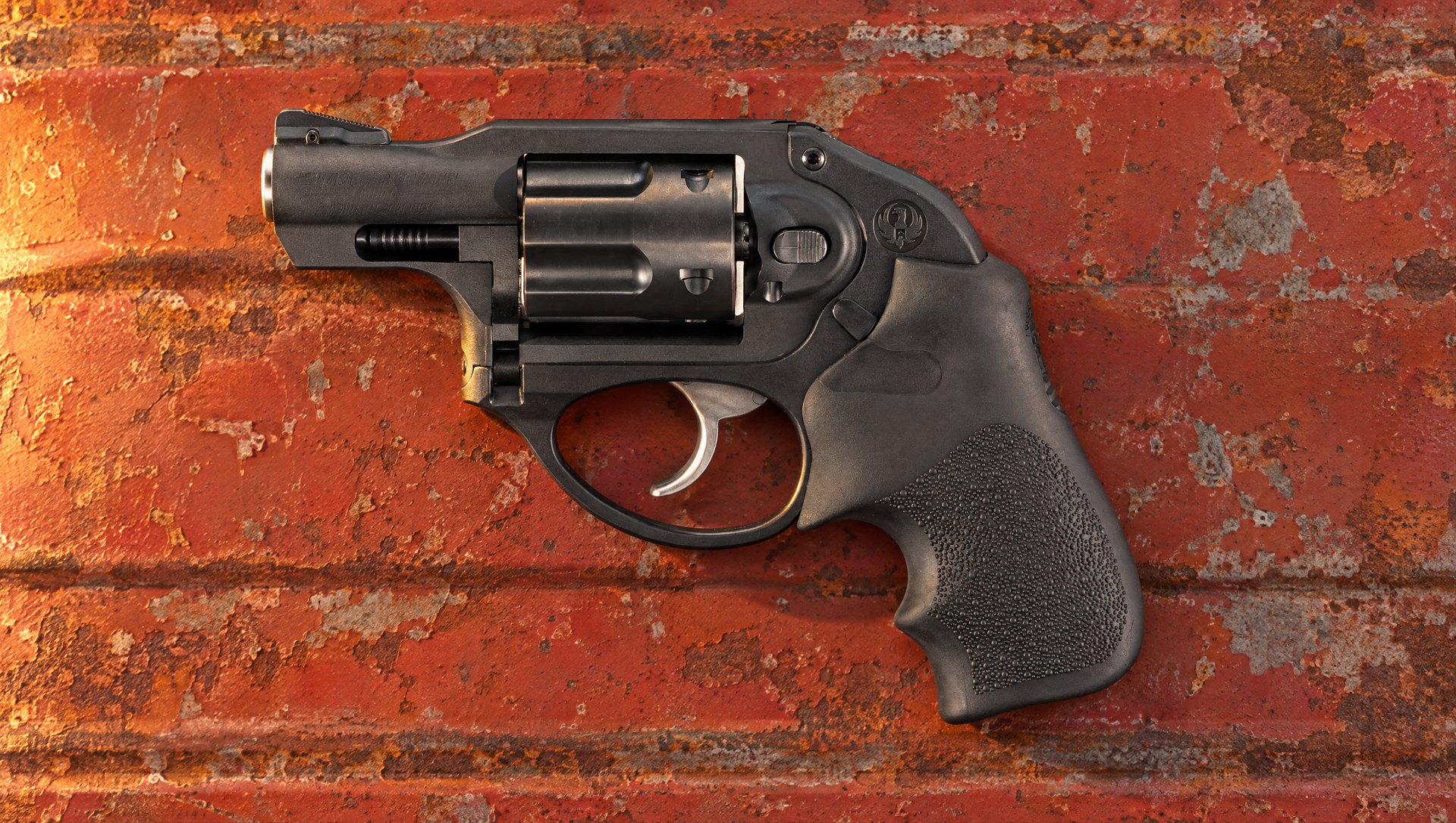 Ruger LCR .38 Special snub-nose revolver lying on the rusted red tailgate of an old farm truck at sunset