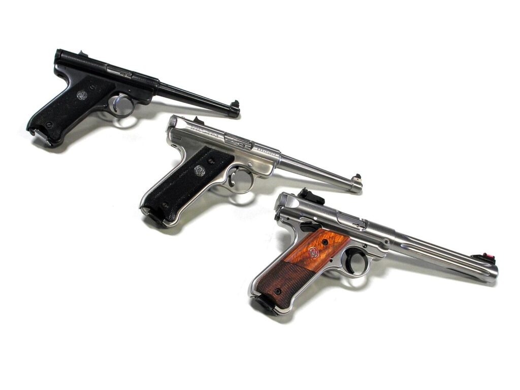 Three Ruger rimfire pistols from the right side: a blued Mark I, a stainless Mark II and a Mark IV Hunter