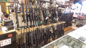 Rack of AR-15 rifles behind a glass display counter in a gun shop