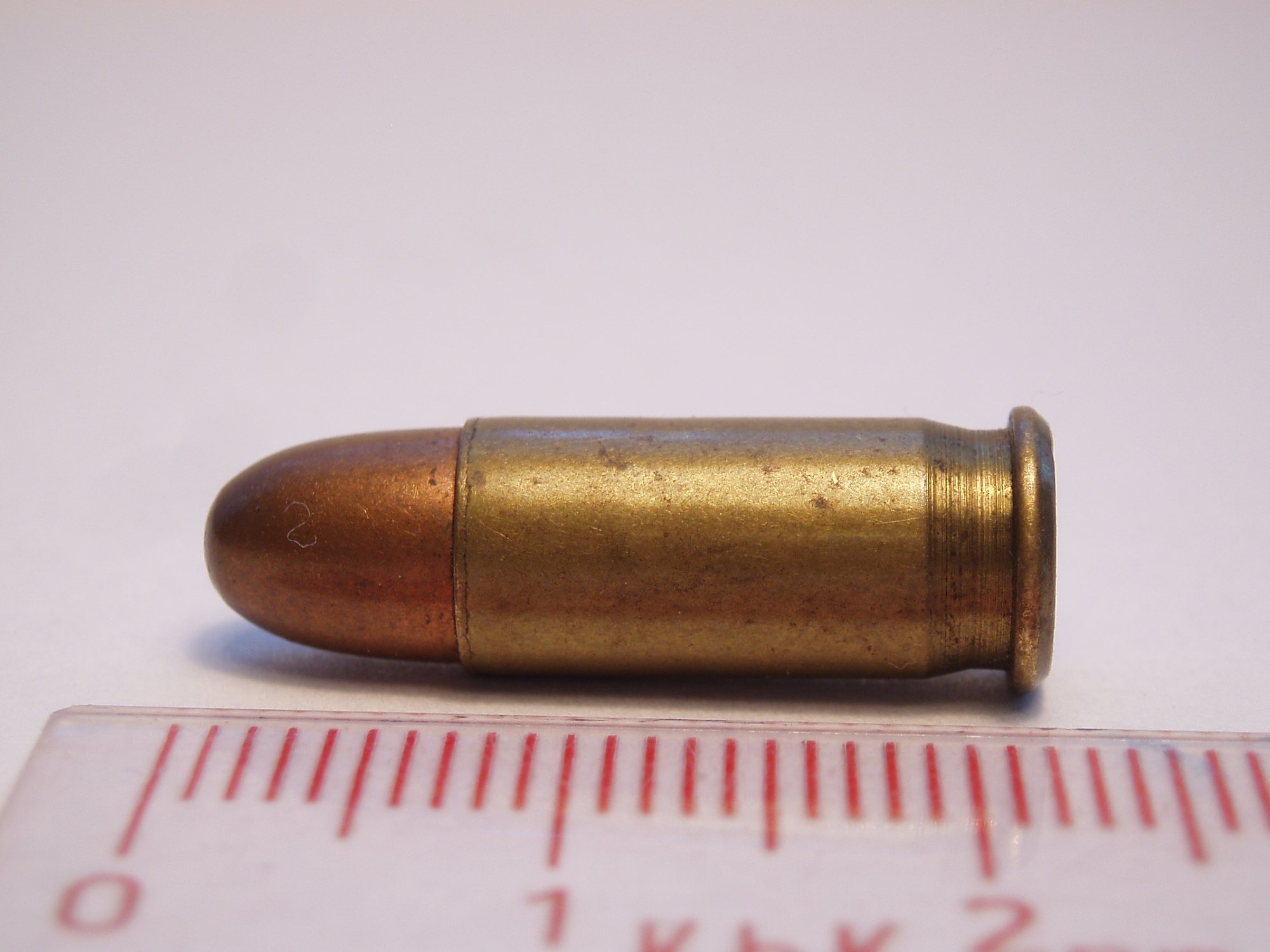 Sellier and Bellot 25 ACP full metal jacket round beside a centimeter ruler
