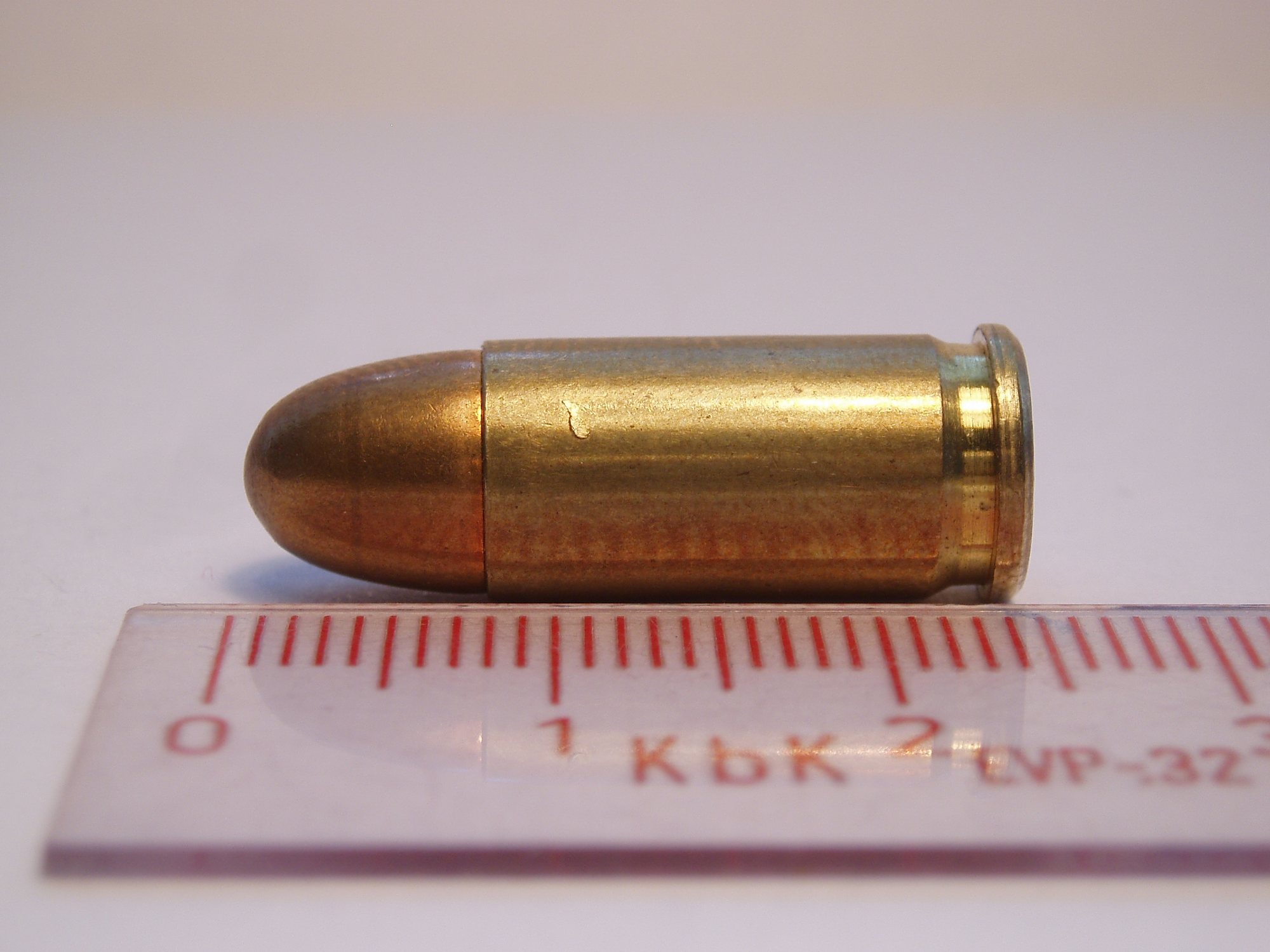 Sellier and Bellot 32 ACP full metal jacket cartridge beside a centimeter ruler