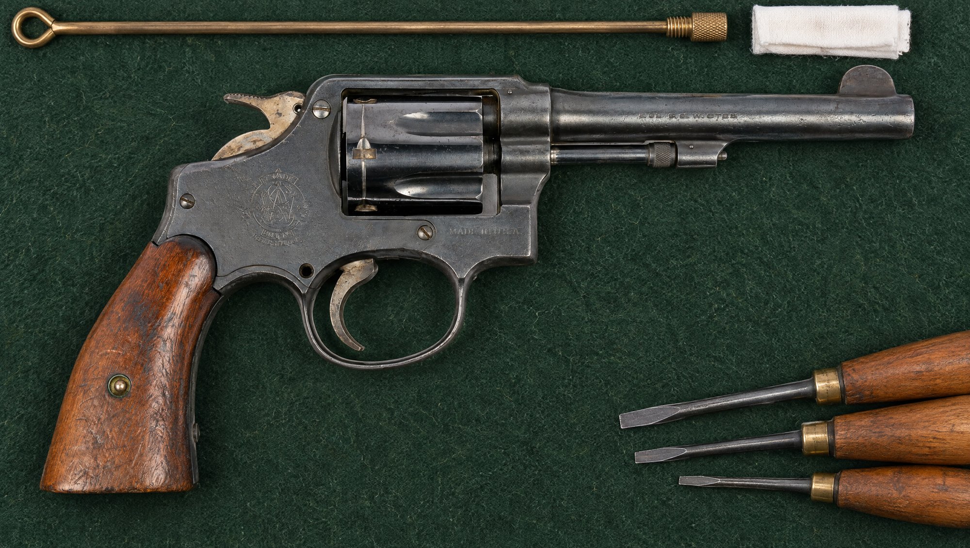 Smith and Wesson Military and Police hand ejector revolver on a green felt gunsmith mat with screwdrivers and a cleaning rod