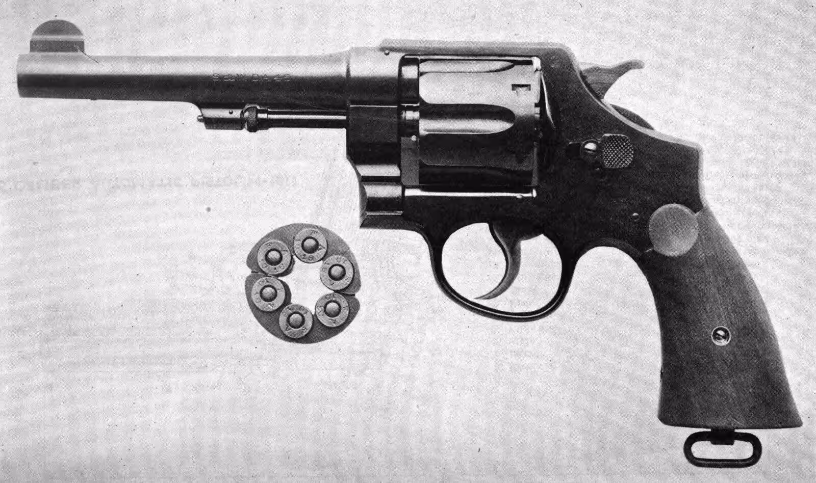 A Smith & Wesson Model 1917 .45 caliber revolver with a lanyard ring on the butt, shown beside six .45 ACP cartridges in half-moon clips, in a U.S. Army Ordnance Department photograph