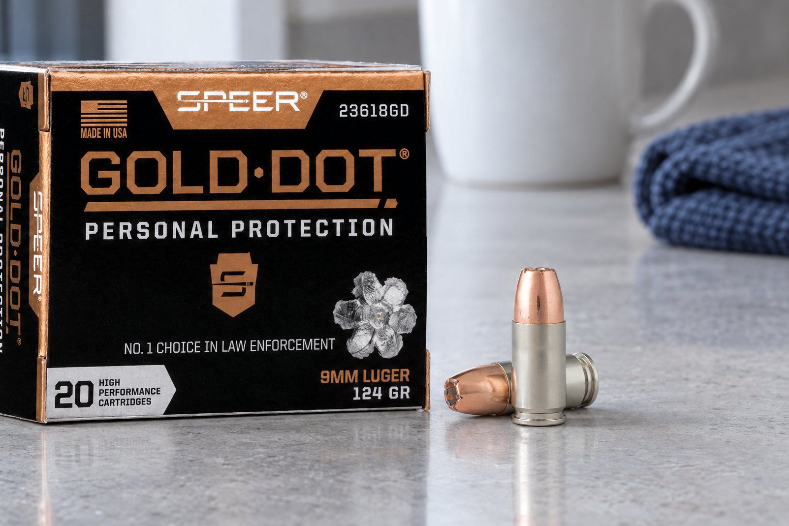 Speer Gold Dot review: 9mm Luger 124 gr box and two cartridges on a gray concrete counter in morning light