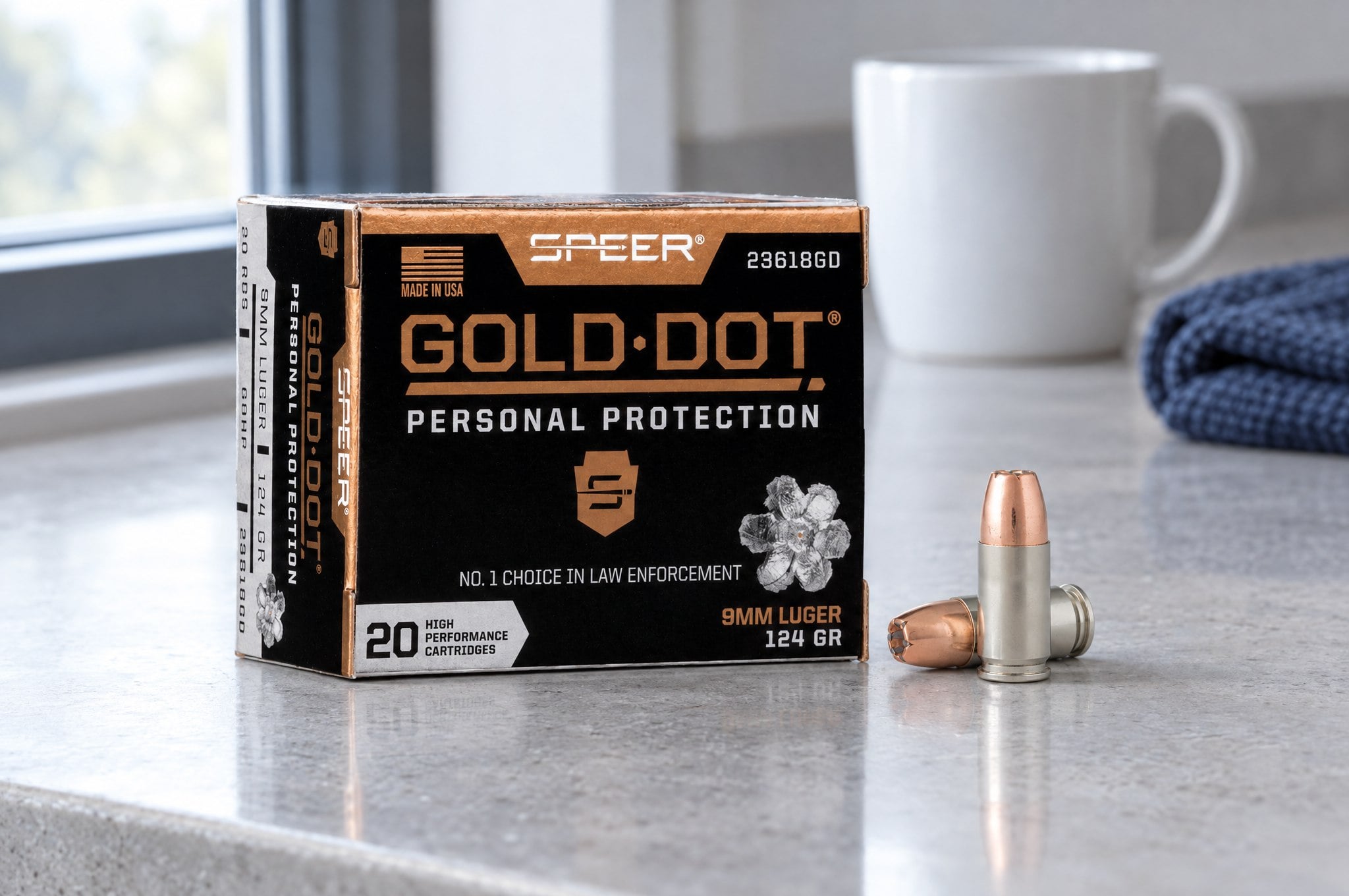 Speer Gold Dot review: 9mm Luger 124 gr box and two cartridges on a gray concrete counter in morning light