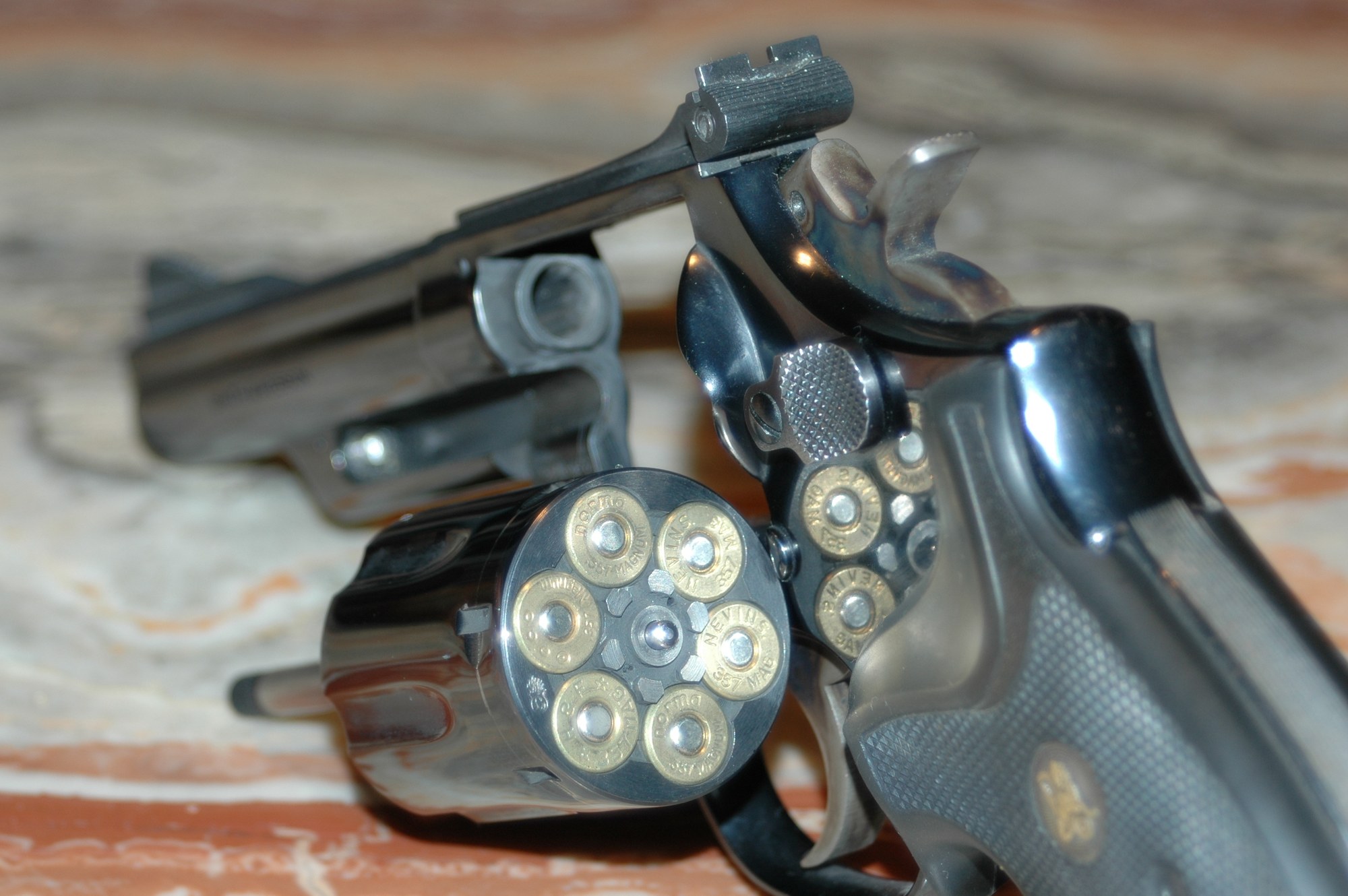 Smith and Wesson Model 19 with cylinder swung open showing six .357 Magnum cartridges